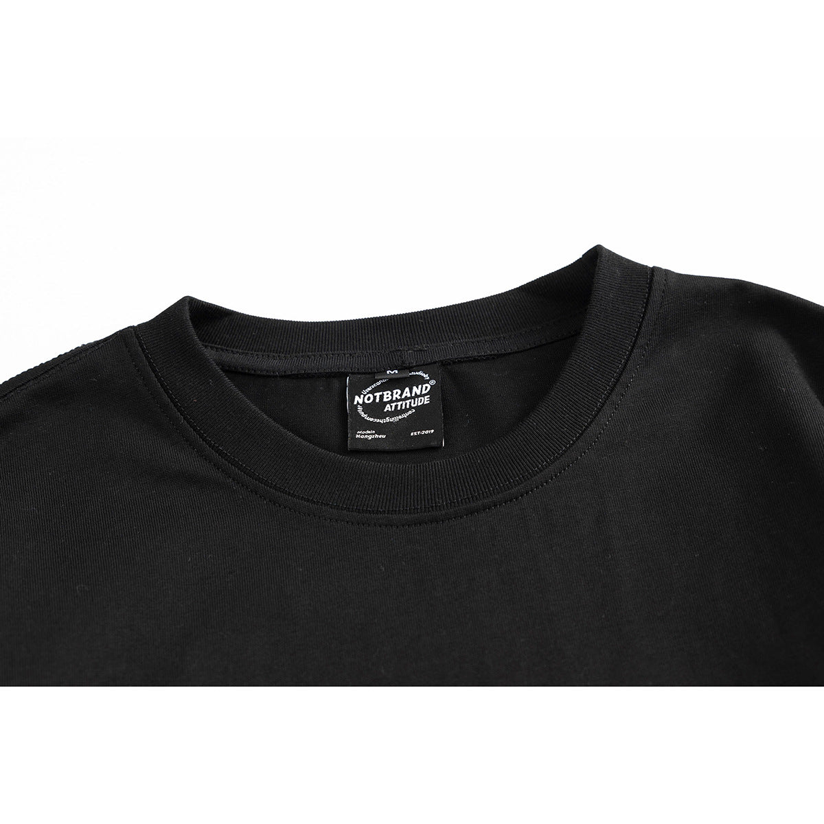 Close-up of a black crew-neck shirt showing its ribbed collar and inner NOTBRAND label.