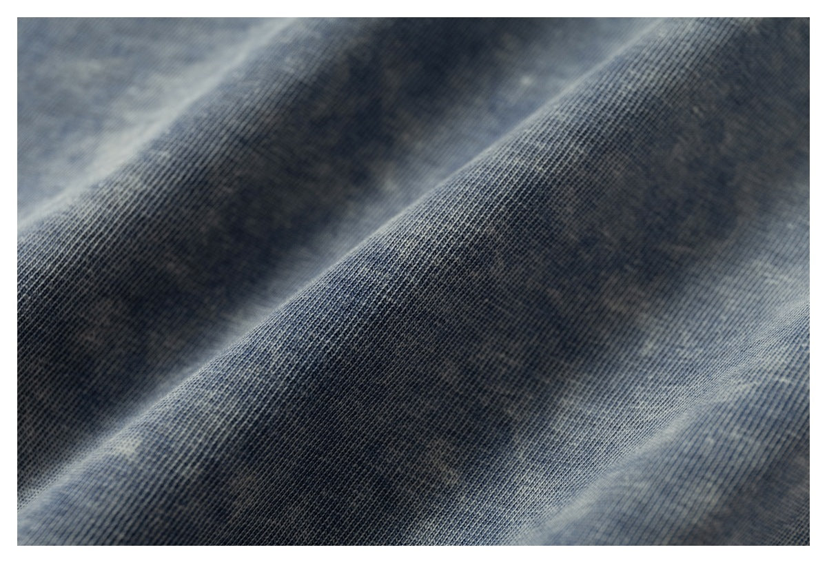 Macro view of the fine knit texture and mottled wash of blue-gray fabric.