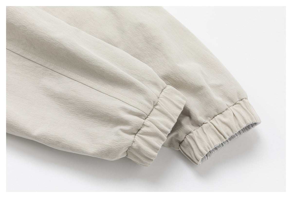 Close-up of beige jacket sleeves with gathered elastic cuffs.