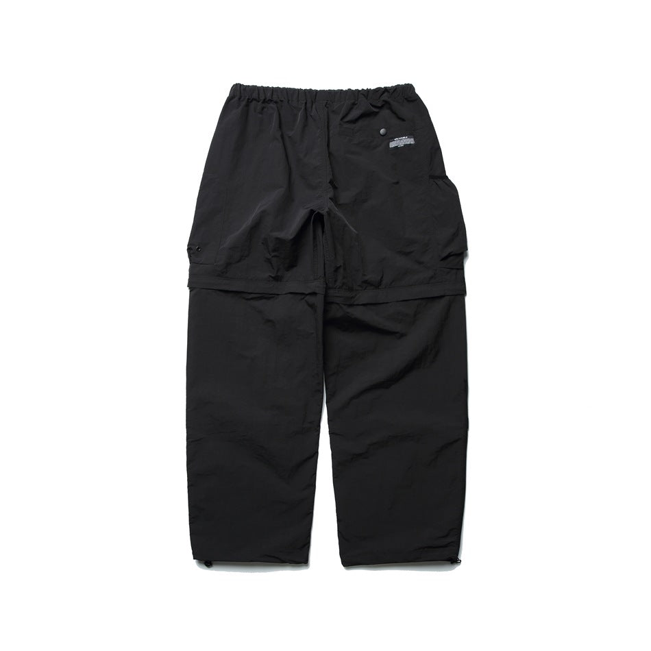 Back view of black cargo pants laid flat, with an elastic waistband, a rear flap pocket and paneled legs.