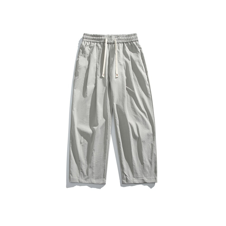 Gray wide-leg drawstring pants with elastic waistband and front pleats, flat lay front view