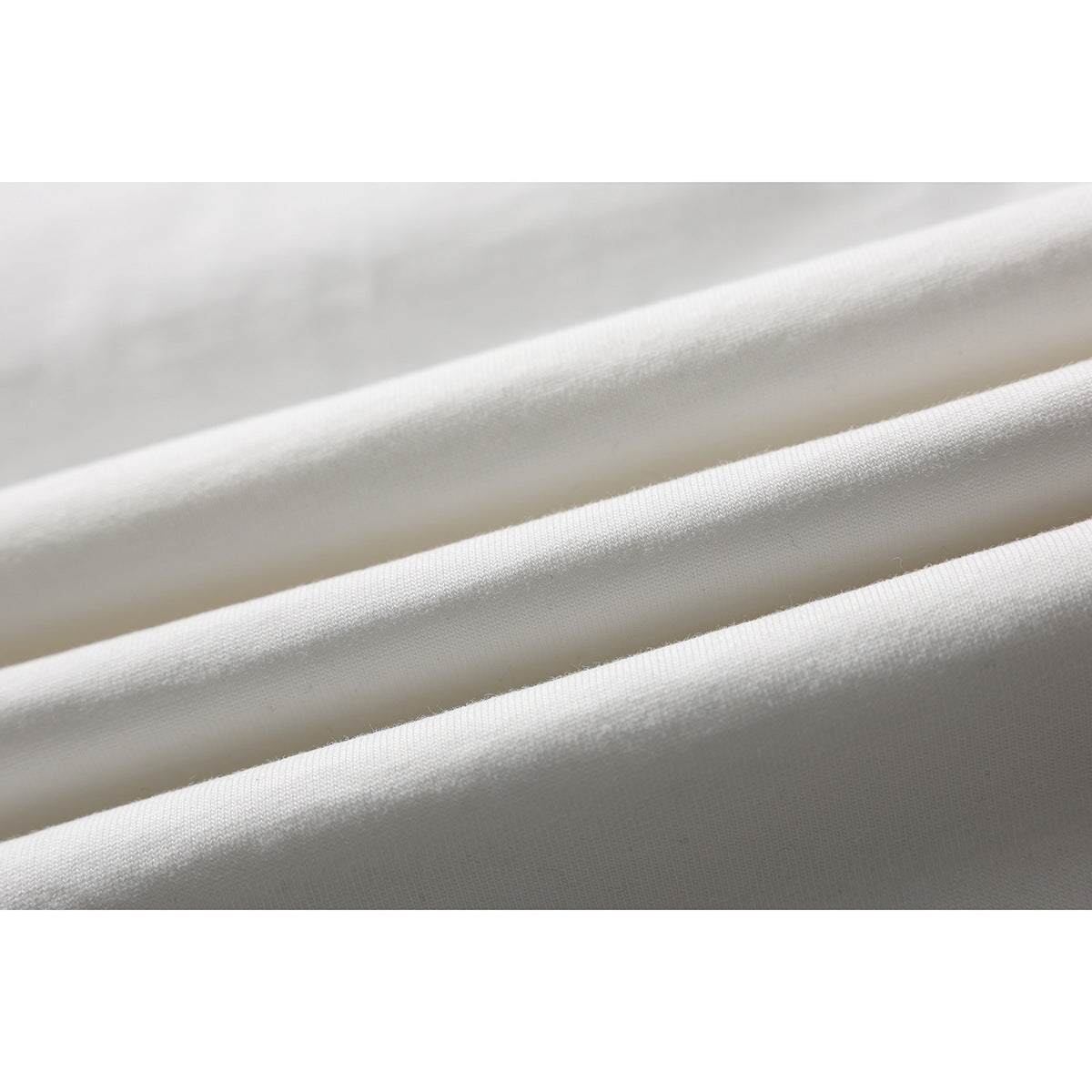 Close-up of white T-shirt fabric draped in parallel folds.
