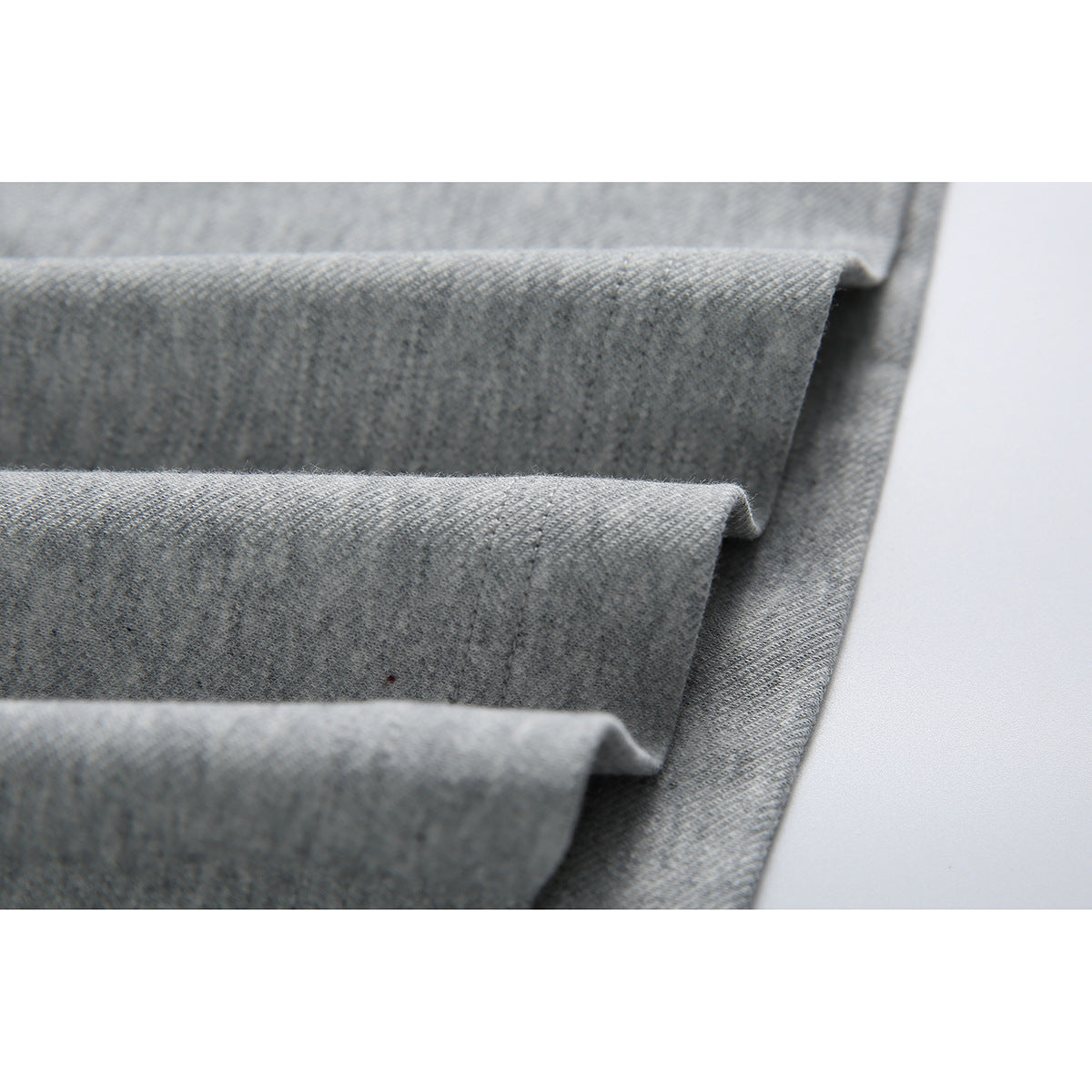 Close-up of gray fabric folds showing the garment’s texture and construction.