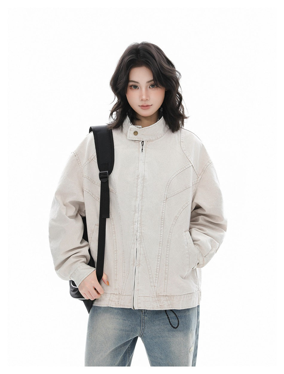 Model wearing a light khaki stand-collar zip jacket with a black shoulder bag strap, hand in pocket, with light-wash jeans
