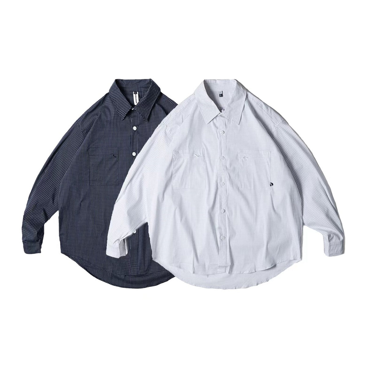 Two long-sleeve button-up shirts shown from the front: one navy with a fine check and one pale gray with a fine check.