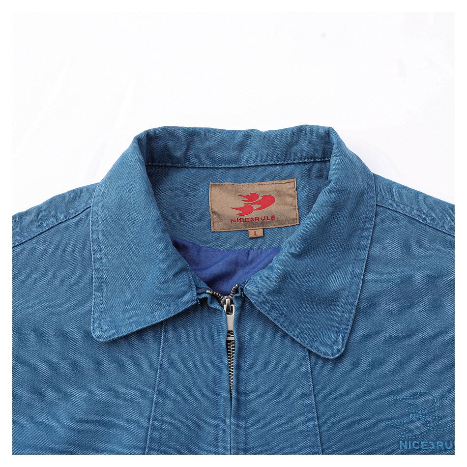Close-up of the blue jacket's collar, front zipper, woven NICEBULLE label, and small embroidered chest logo.