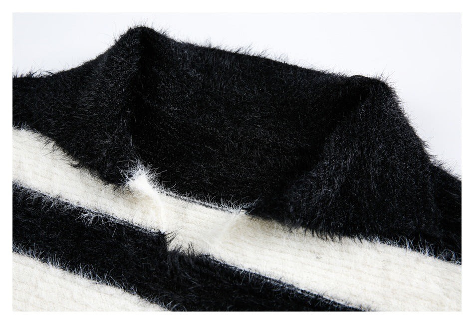 Close-up of a fuzzy black garment edge crossed by a broad ivory stripe.