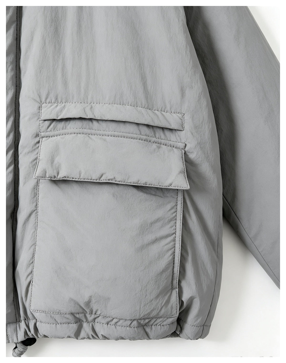 Close-up of a light gray jacket sleeve and large flap pocket with visible stitching.