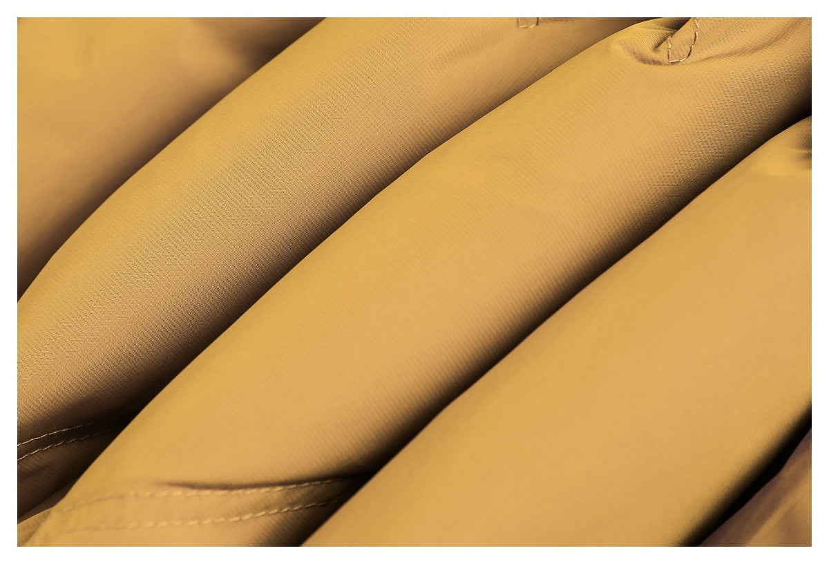 Close-up of folded mustard-yellow jacket fabric showing its surface texture and stitched seams.