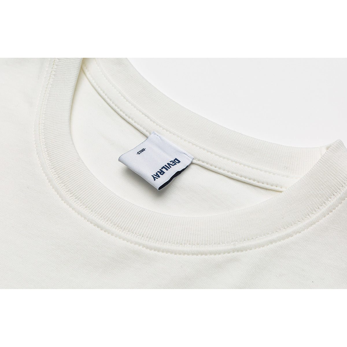 Close-up of an ivory crew-neck shirt collar and sewn-in neck label.