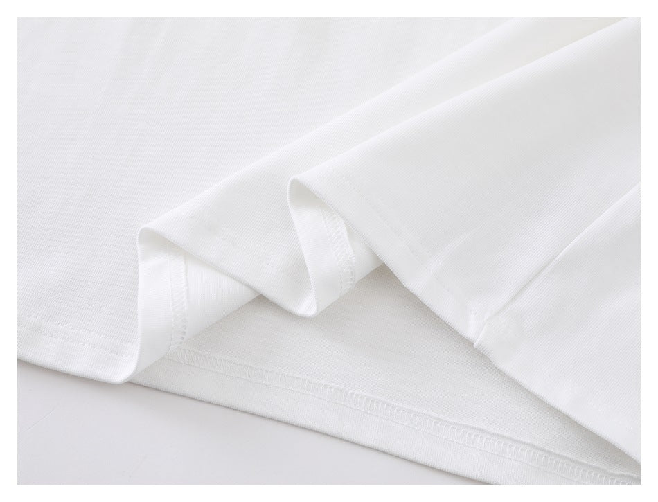 Close-up of the white shirt's folded fabric, sleeve edge, and stitched hem.