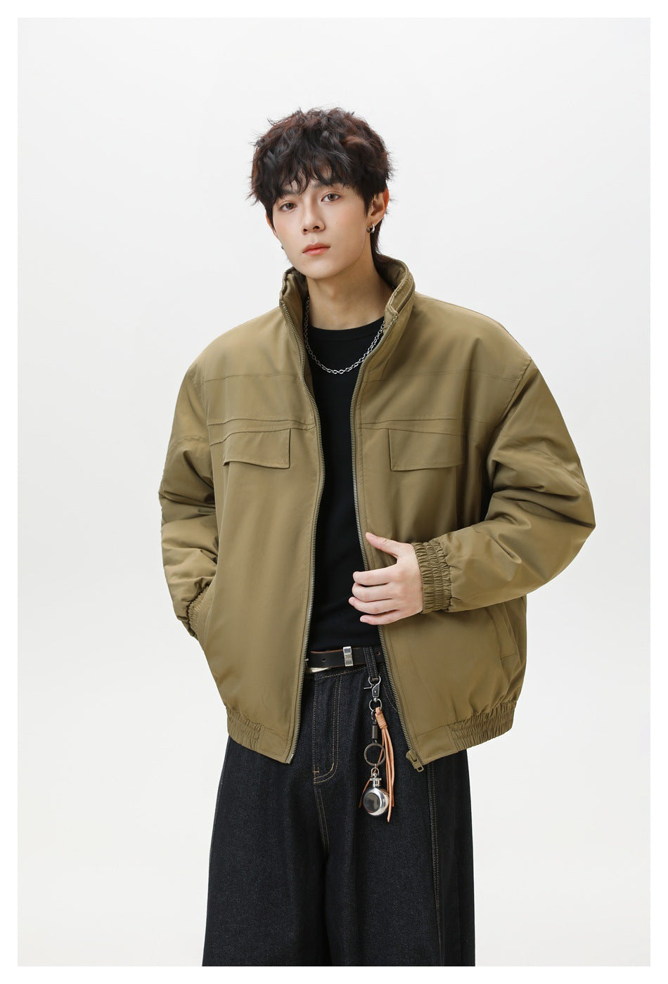 Model wearing an olive-brown jacket partly unzipped, showing its stand collar and flap chest pockets.