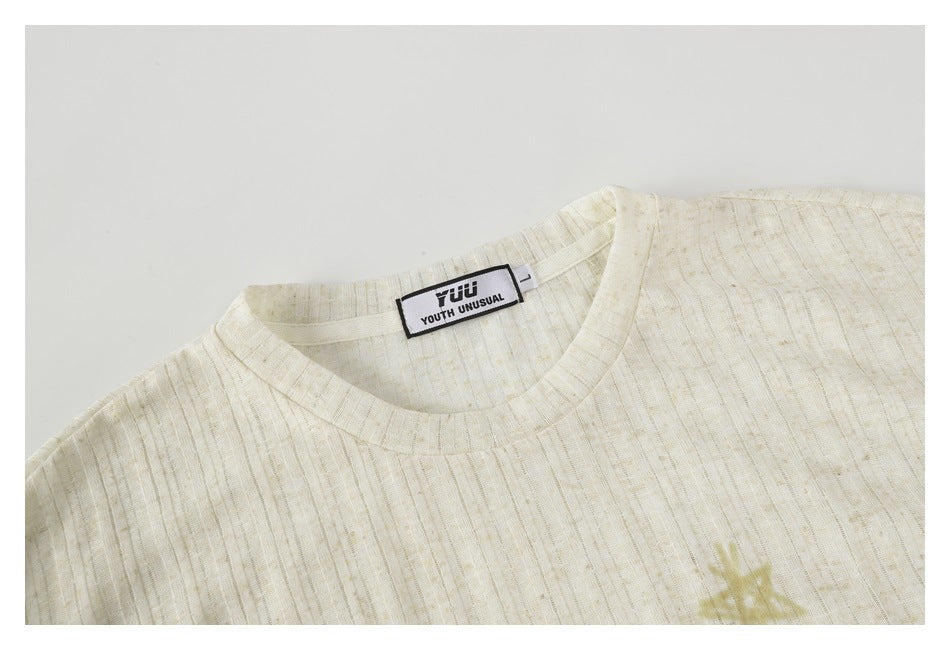 Close-up of the ivory shirt's crew neck and upper chest, with part of a star print visible.