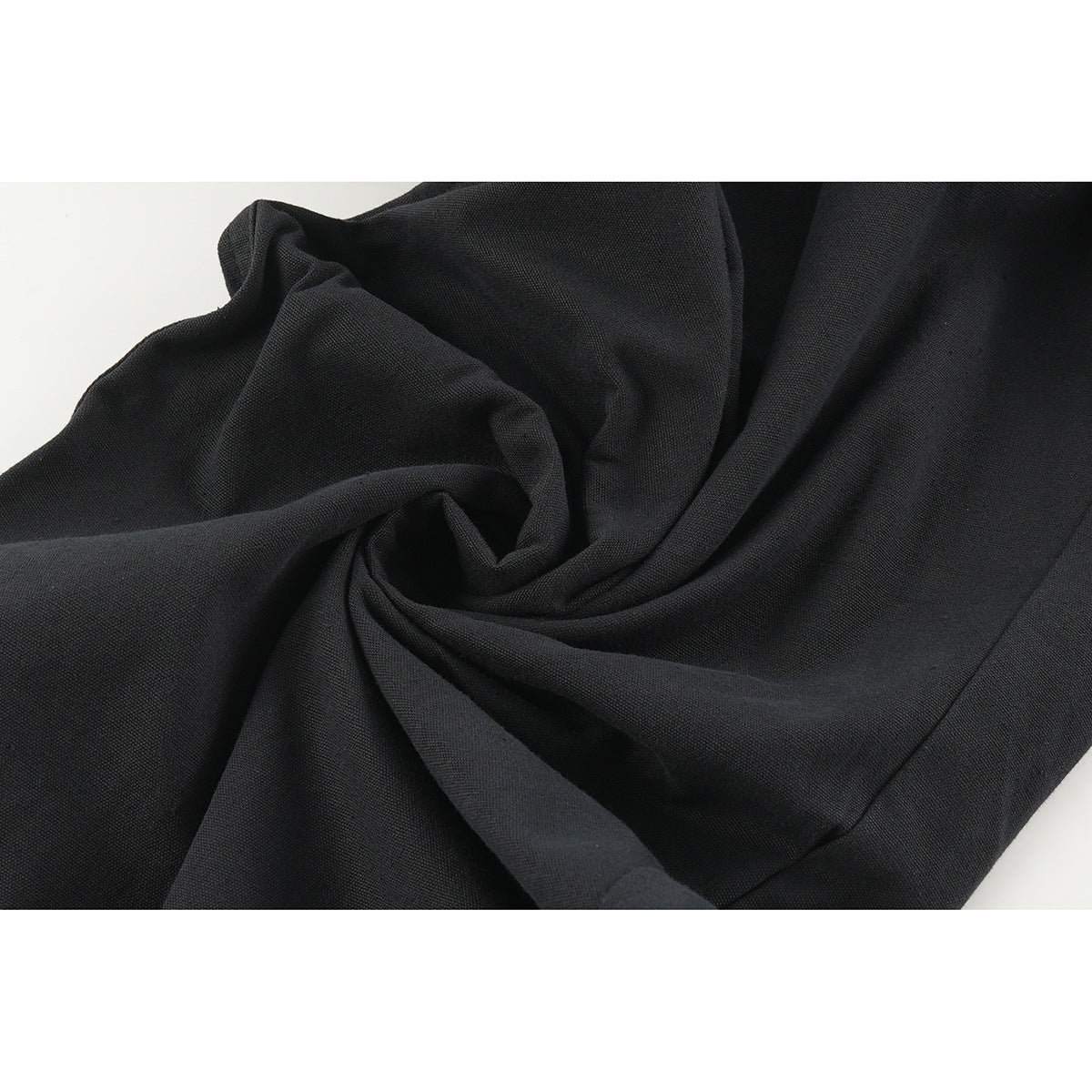 Close-up of black fabric gathered into soft folds.