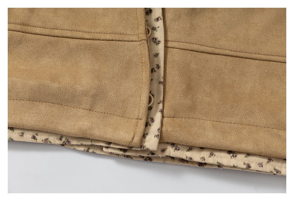 Close-up of tan garment panels with stitched seams, buttons, and cream floral-print lining along the edges.
