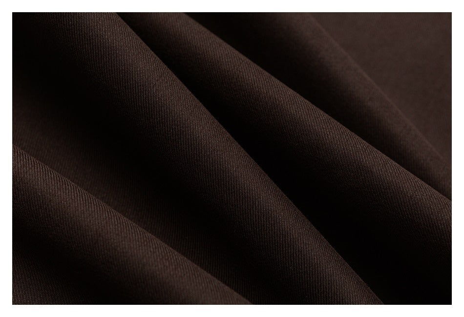 Close-up of dark brown fabric draped in soft folds, showing its fine texture.