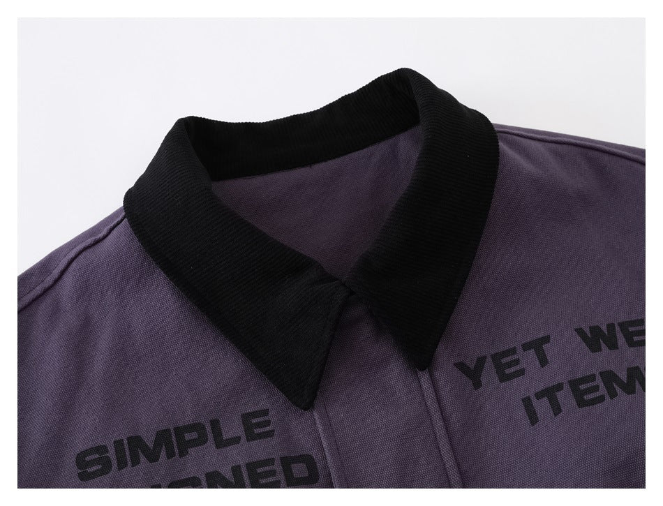 Close-up of a purple jacket's black collar and upper chest with partial black printed lettering.