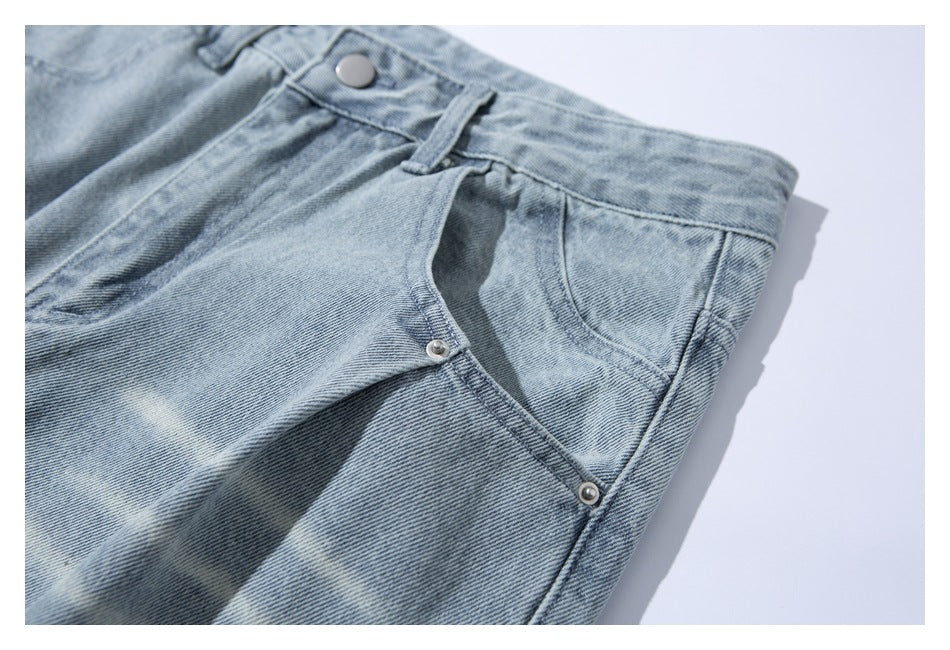 Angled close-up of a light-wash jeans front pocket, rivets, waistband and button.
