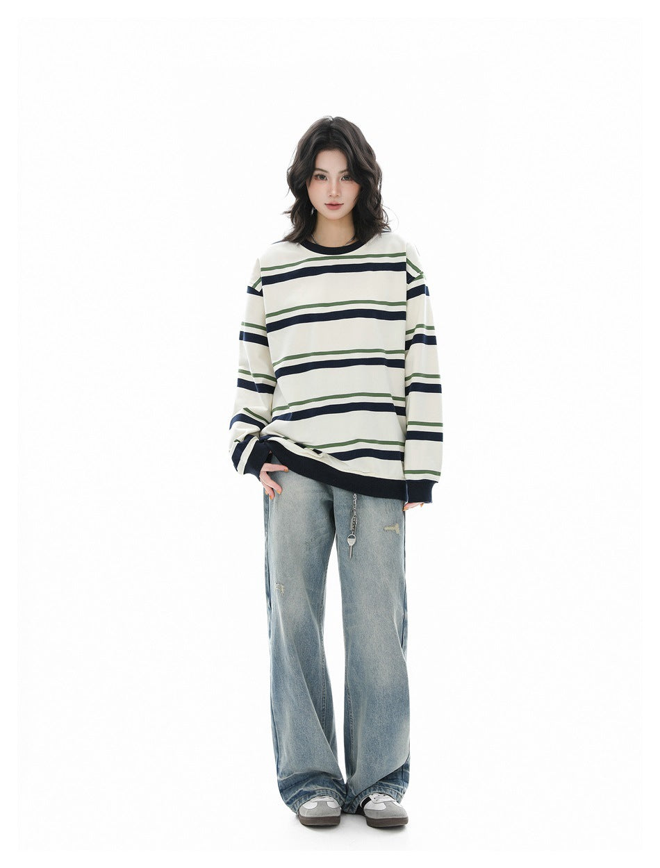 Full-length model wearing an ivory striped long-sleeve shirt with dark trim and wide-leg light-wash jeans.