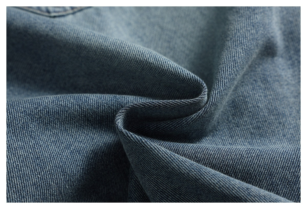 Close-up of blue denim folded to show its diagonal weave and textured surface.