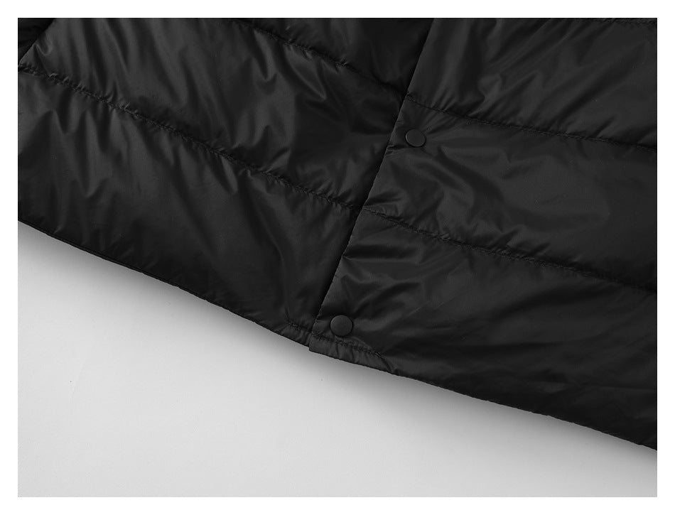 Close-up of the black vest's lower front snap placket and quilted hem.