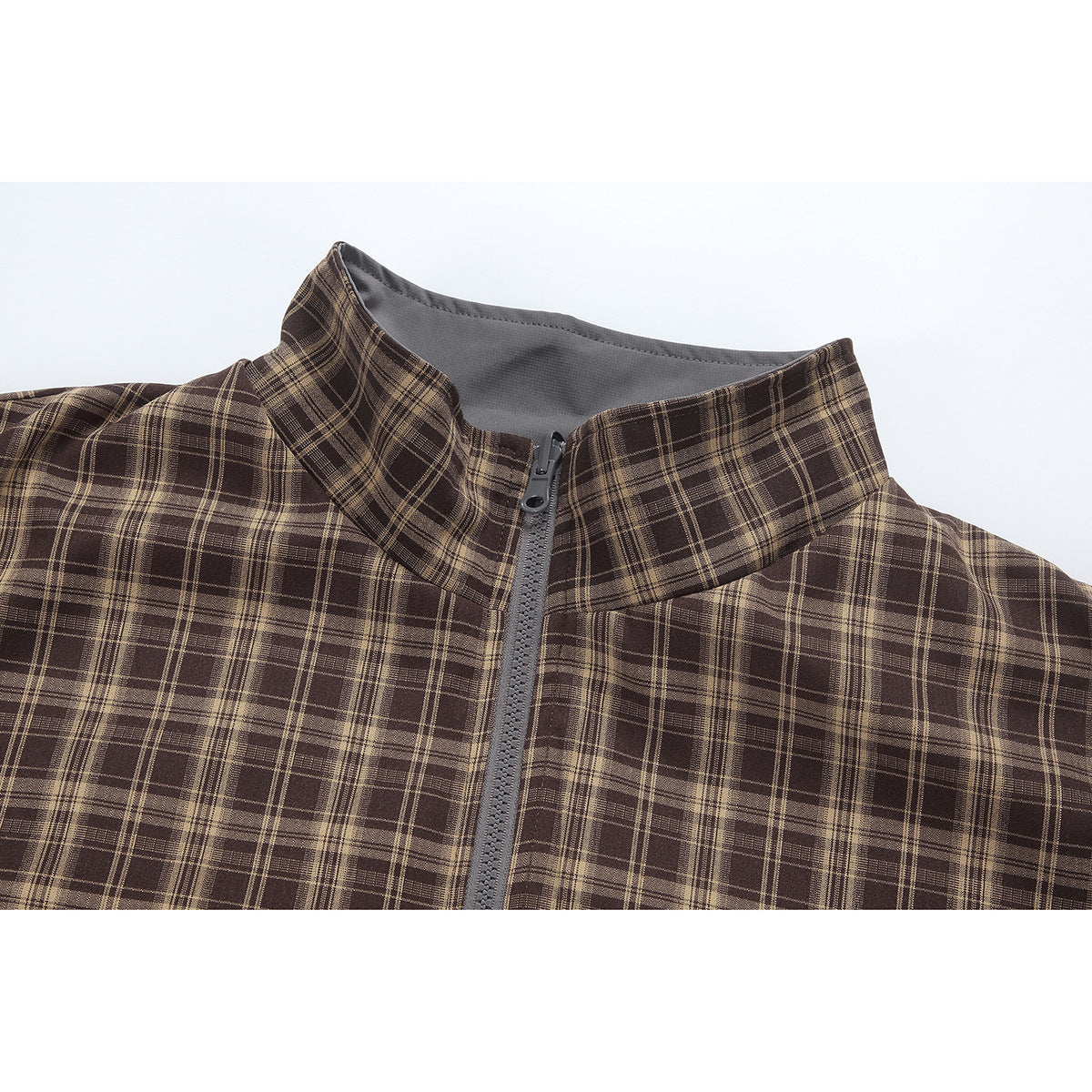 Close-up of a brown plaid jacket's stand collar and gray center zipper.