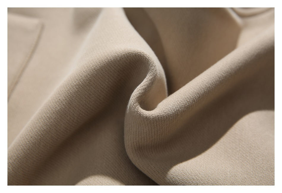 Macro view of beige garment fabric folded to show its smooth, fine-knit surface.
