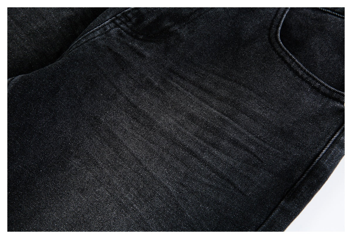 Close-up of the black denim fabric and stitching on the jeans.