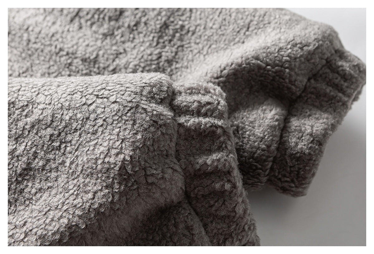 Close-up of gray fleece fabric folded to show a thick edge and stitched seam.
