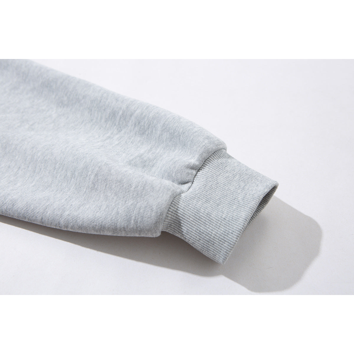 Close-up of a light gray jacket sleeve ending in a ribbed cuff.