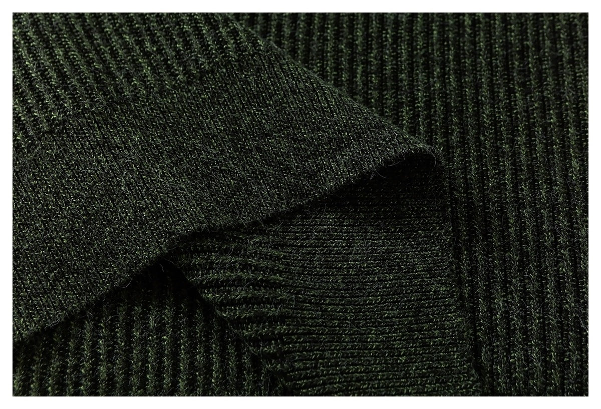Deep green knitted fabric folded to show contrasting rib directions and a raised edge.