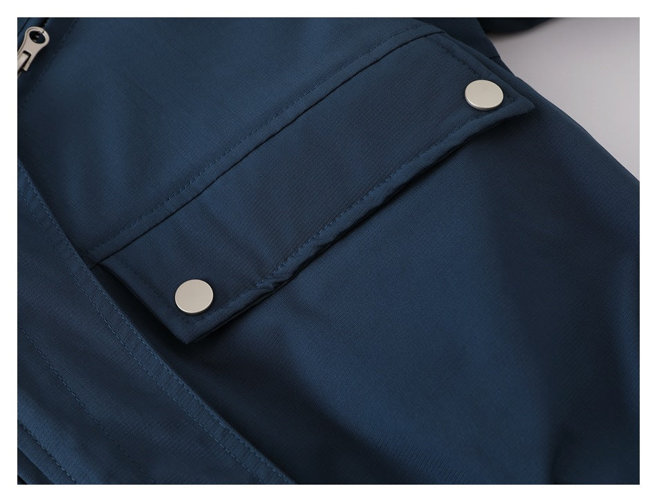 Close-up of a navy jacket pocket flap with two silver snap fasteners.