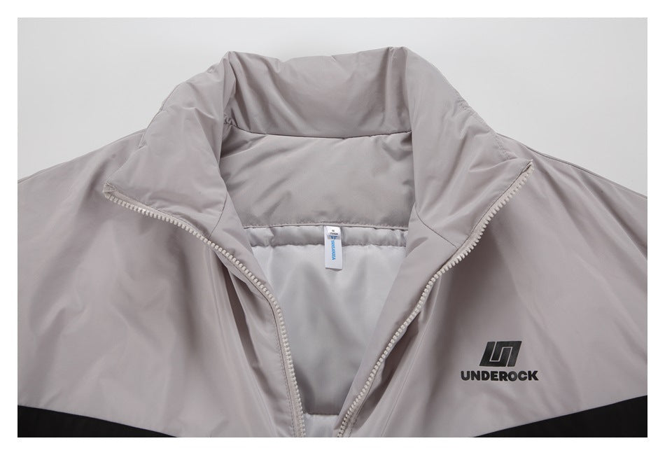 Close-up of the light gray jacket's open collar, zipper, inner lining, and UNDEROCK chest logo.