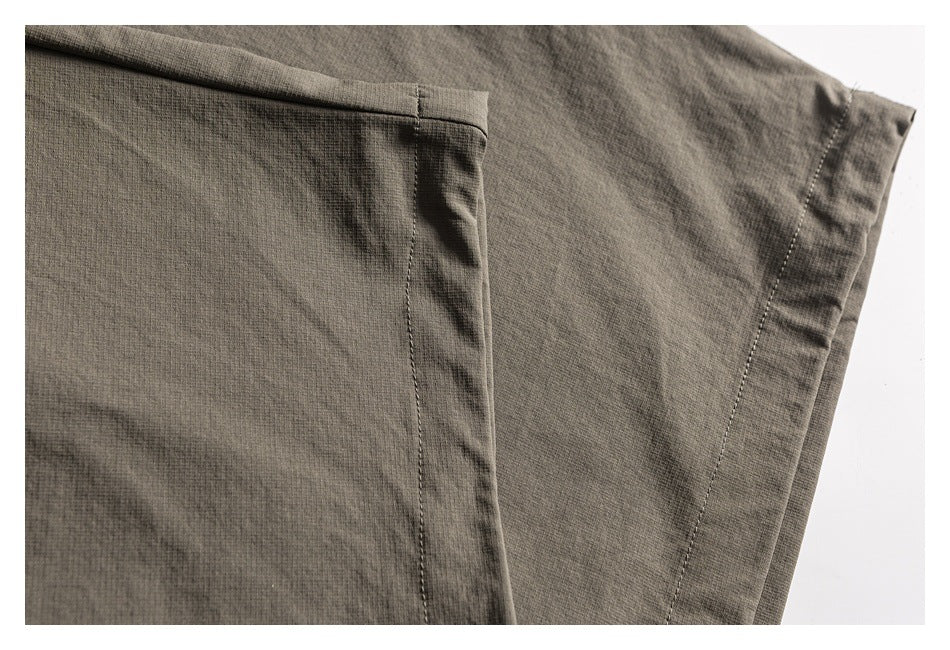 Close-up of a trouser leg showing a stitched pocket edge and hem seam.