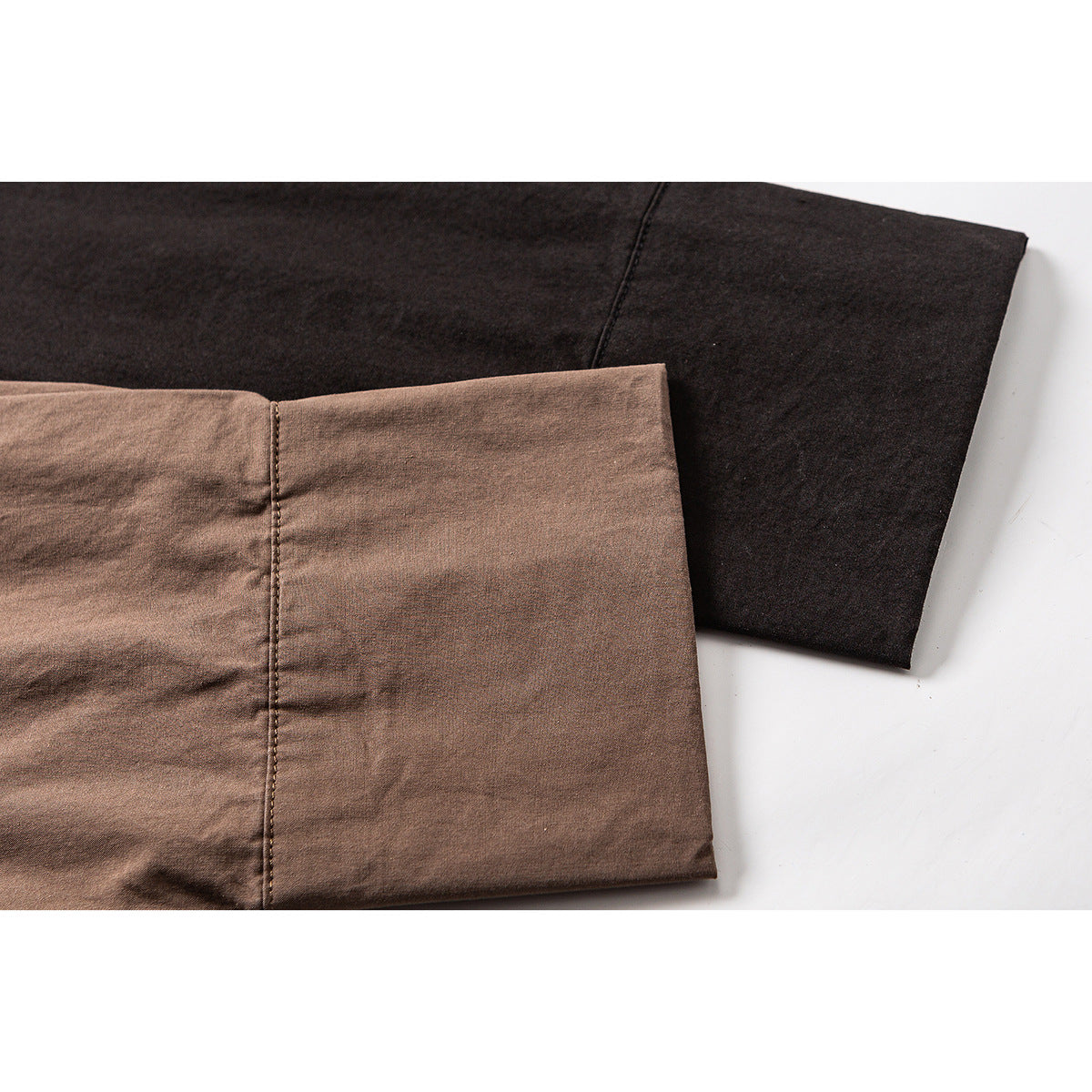 Close-up of brown and dark shirt cuffs with visible seams and stitching.