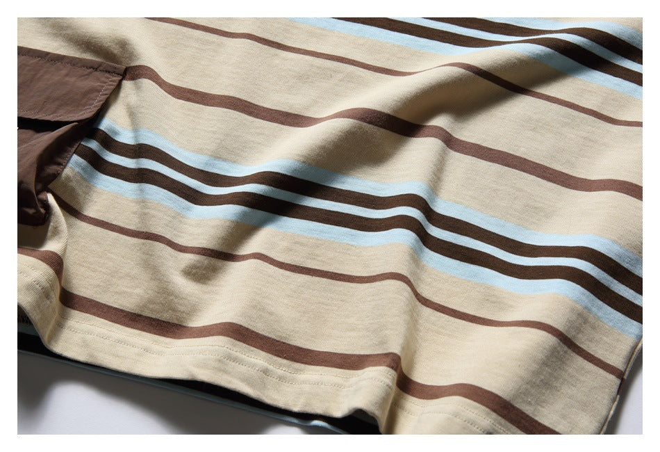 Close-up of horizontal brown and pale blue stripes across the beige T-shirt body and its lower hem.