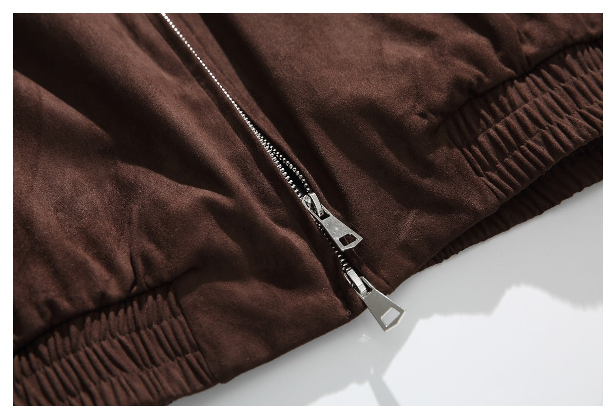 Close-up of a dark brown jacket hem with ribbed edging and a silver double zipper.