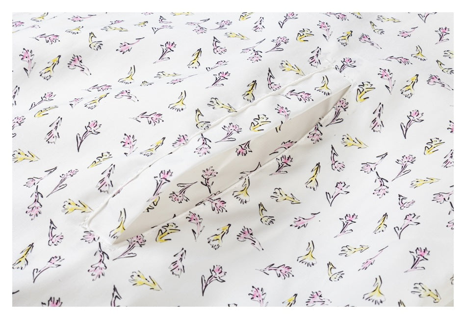 Close-up of a slit or pocket opening on a white garment with a scattered pink and yellow floral print.