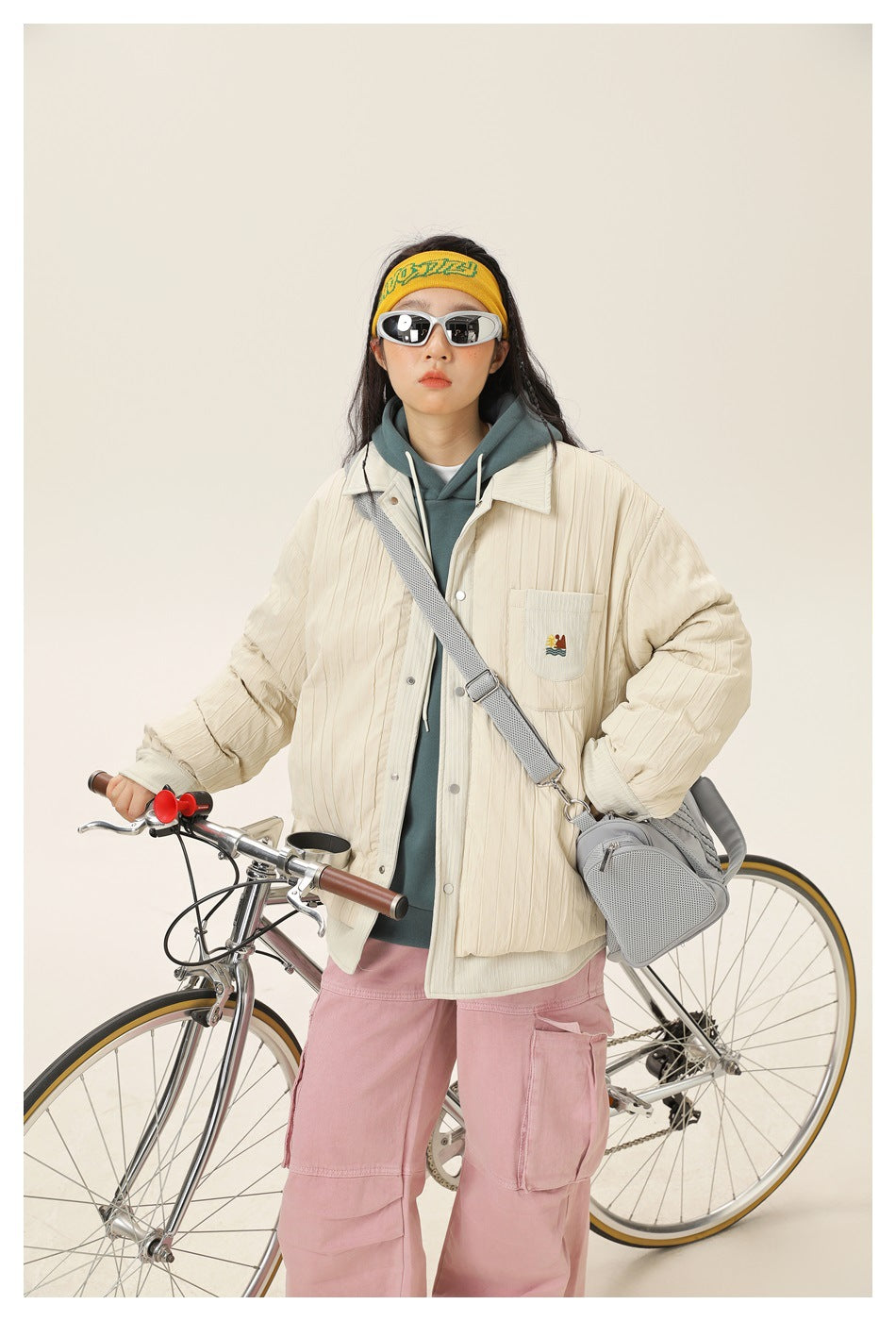 Closer front view of a model wearing a cream quilted snap-front jacket with a chest pocket and ribbed cuffs.