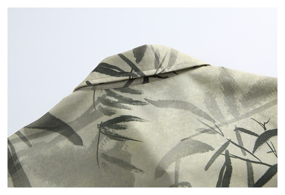 Close-up of the folded collar and shoulder area of a beige shirt with dark bamboo brushstroke print.