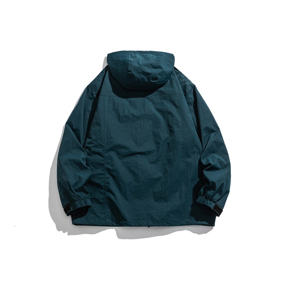 Back view of a deep teal hooded jacket with long sleeves and elastic cuffs.
