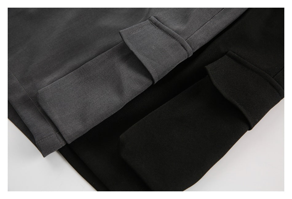 Close-up of the wide hems on charcoal gray and black pants.