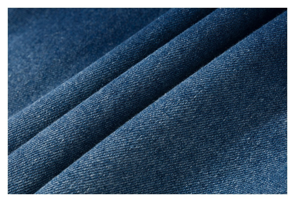Macro view of blue denim fabric draped in soft folds.