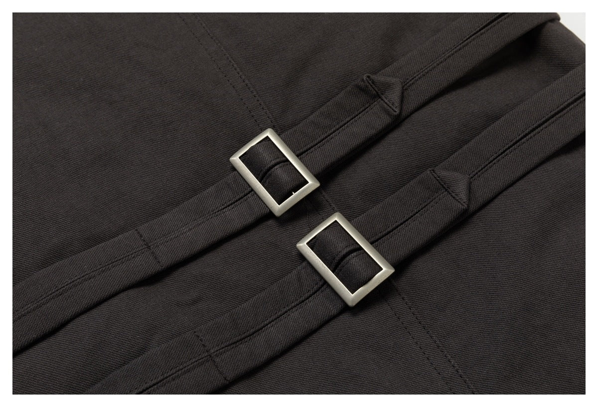 Close-up of two rectangular silver buckles on straps across charcoal fabric.