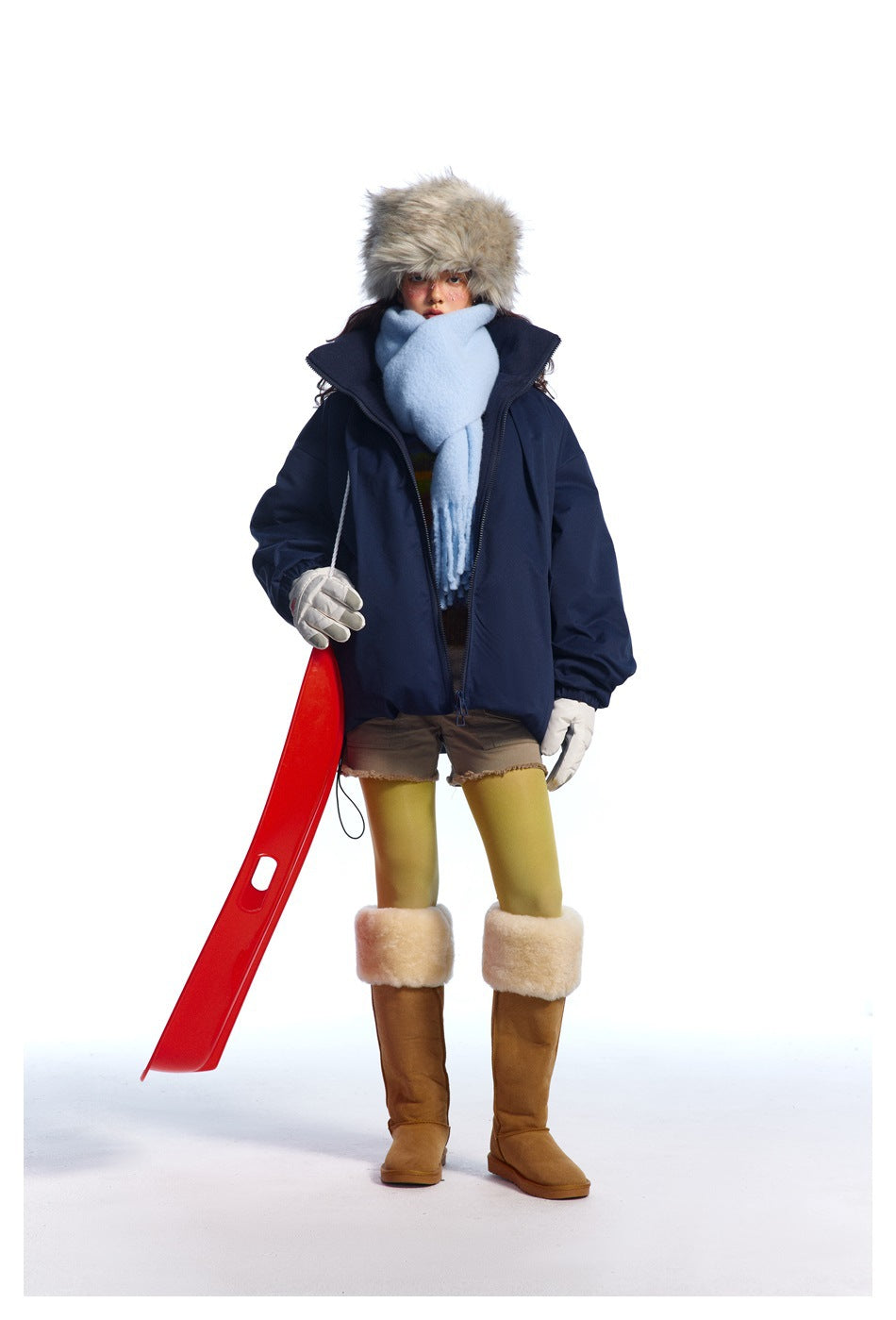 Front view of a model wearing a dark navy oversized jacket with a light blue scarf and winter accessories.