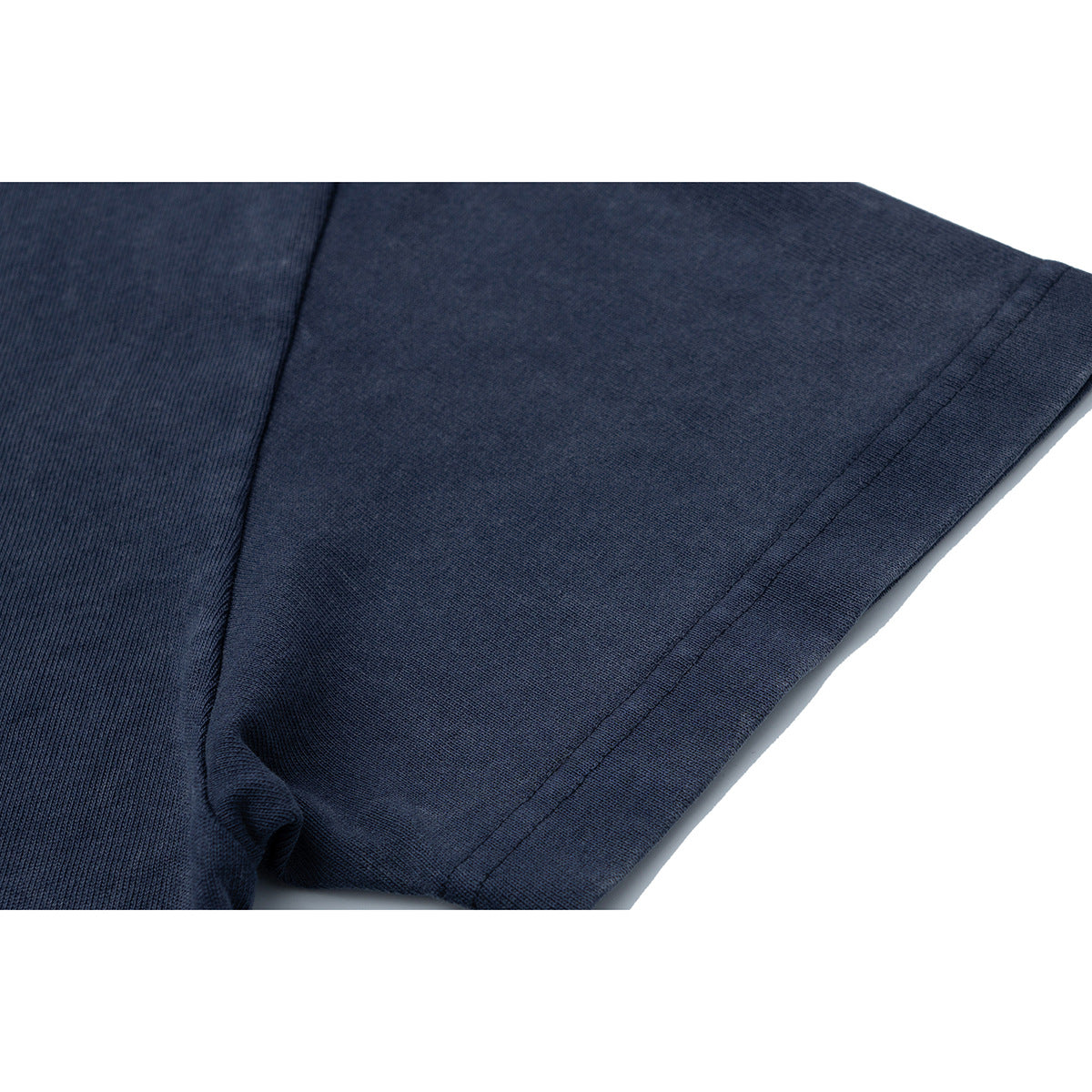 Close-up of the navy T-shirt's sleeve and stitched hem seam.