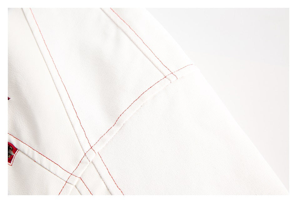 Close-up of intersecting red-stitched seams on the white jacket's sleeve and shoulder.