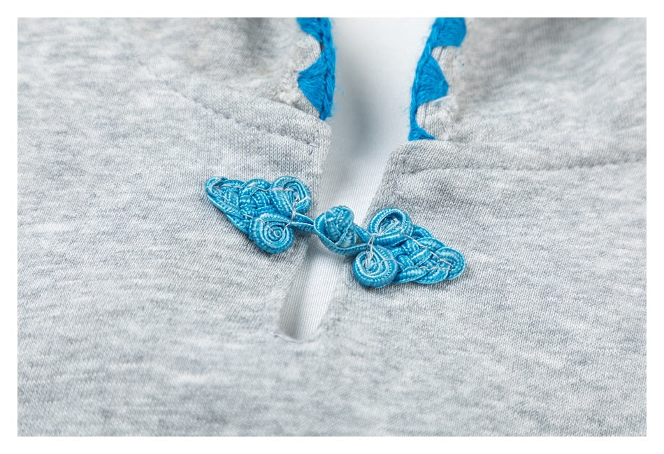 Close-up of a bright blue frog closure on heather gray fabric.