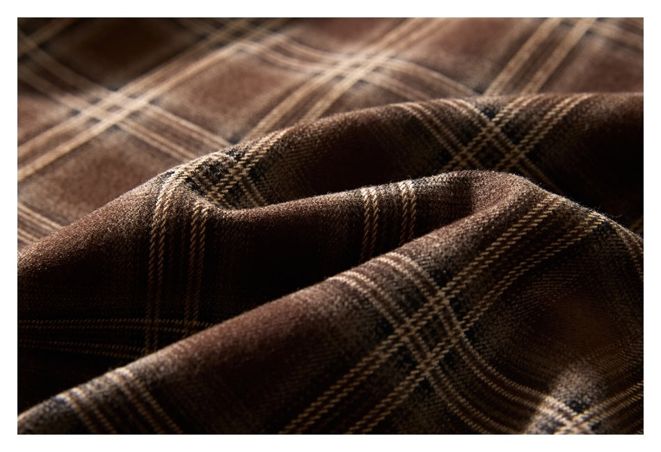 Close-up of brown plaid fabric with dark and tan intersecting stripes.
