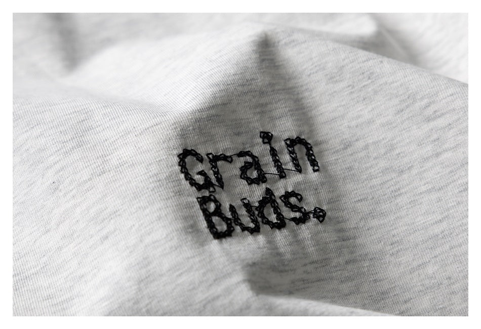 Close-up of black embroidered text on light gray marl fabric.